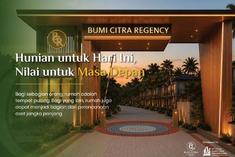 Gerbang masuk kawasan menjelang malam, dengan jalan berpaving menuju deretan rumah dua lantai